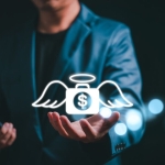 Angel investor concept. Businessman holding money bag icon with wing