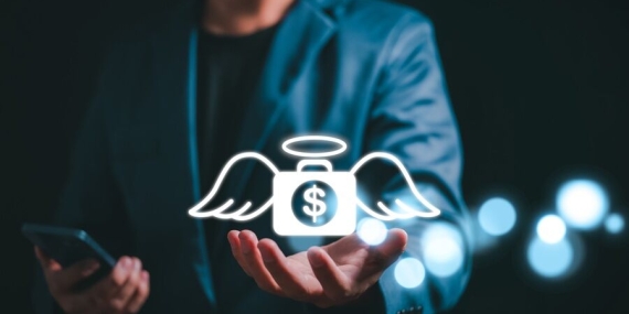 Angel investor concept. Businessman holding money bag icon with wing