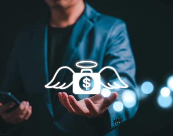 Angel investor concept. Businessman holding money bag icon with wing